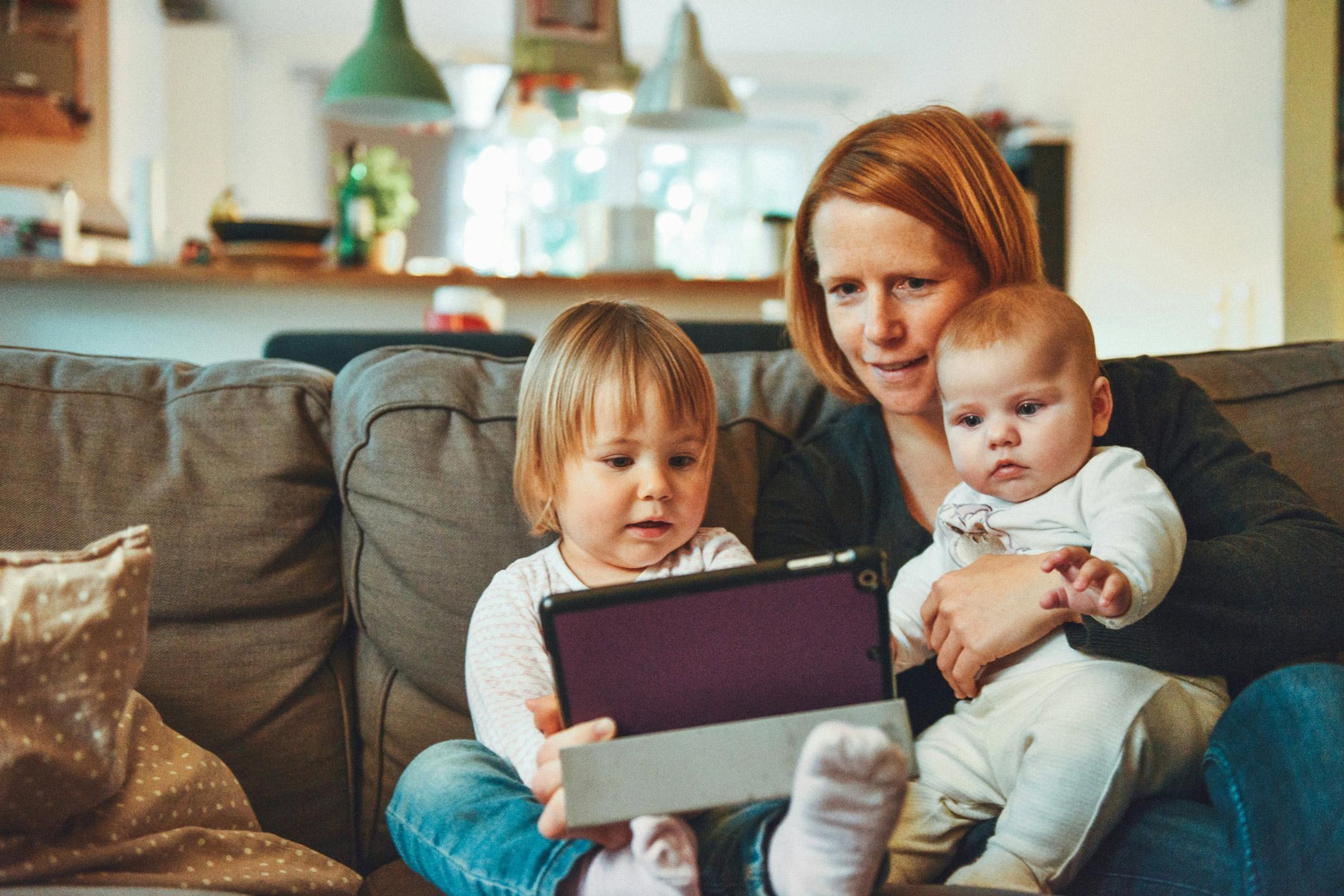 vrouw met kinderen op schoot